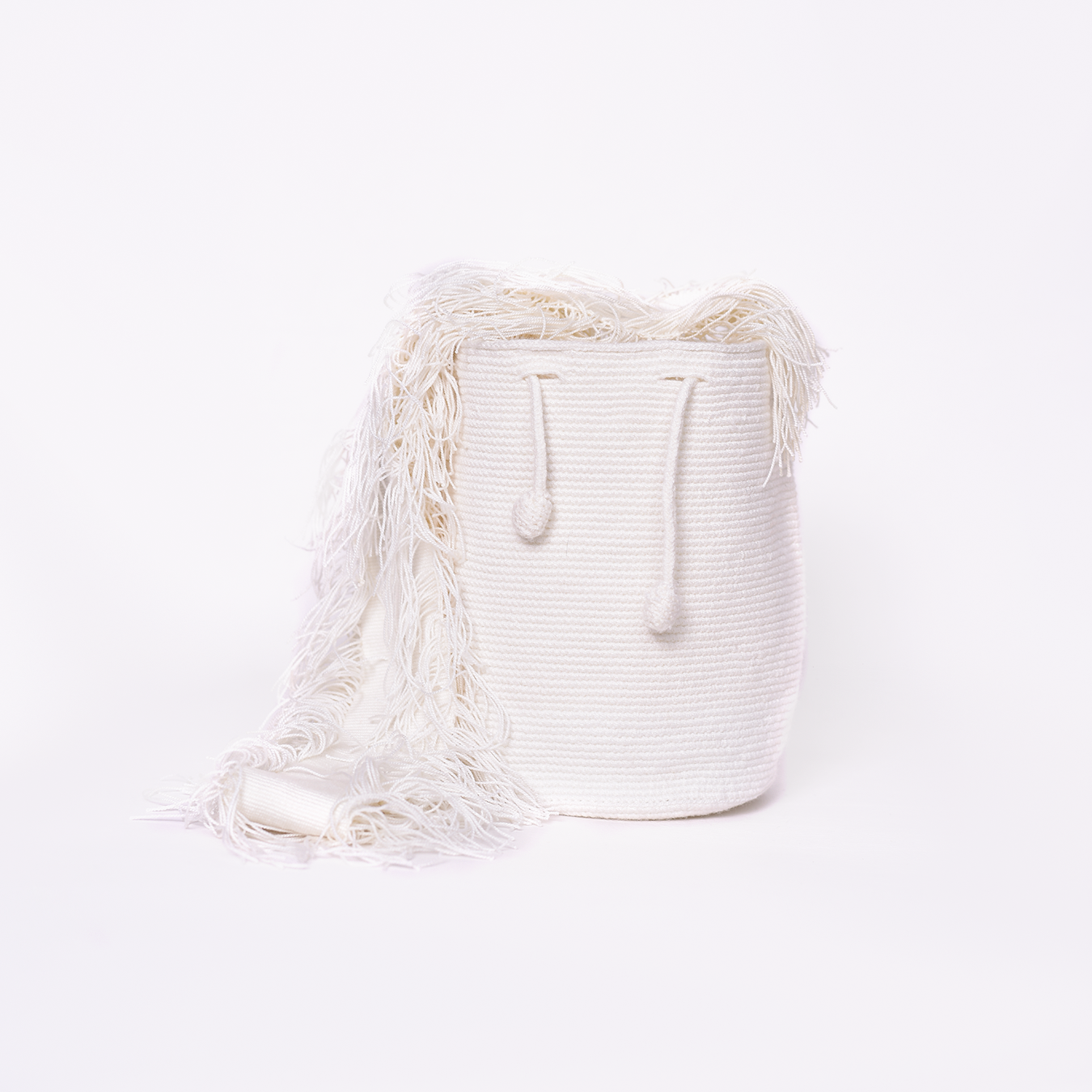 Mochila Flecos, pieza artesanal hecha a mano por artesanas de la comunidad Wayuu en el norte de Colombia. Confeccionada con hilos de algodón y flecos de seda dorada, combina la tradición Wayuu con un diseño vibrante y sofisticado. Su asa larga permite llevarla cruzada, ofreciendo un accesorio único, versátil y lleno de personalidad. Mochila Wayuu, Mochila artesanal, mochila colombiana.