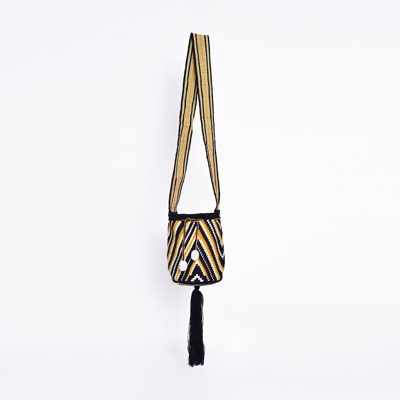 Mochila Nadina, bolso artesanal colombiano tejido a mano por artesanas Wayuu con hilos de algodón. Incluye asa larga, gasa ajustable, detalles únicos y bailarina colgante. Pieza única que combina tradición, cultura y estilo."