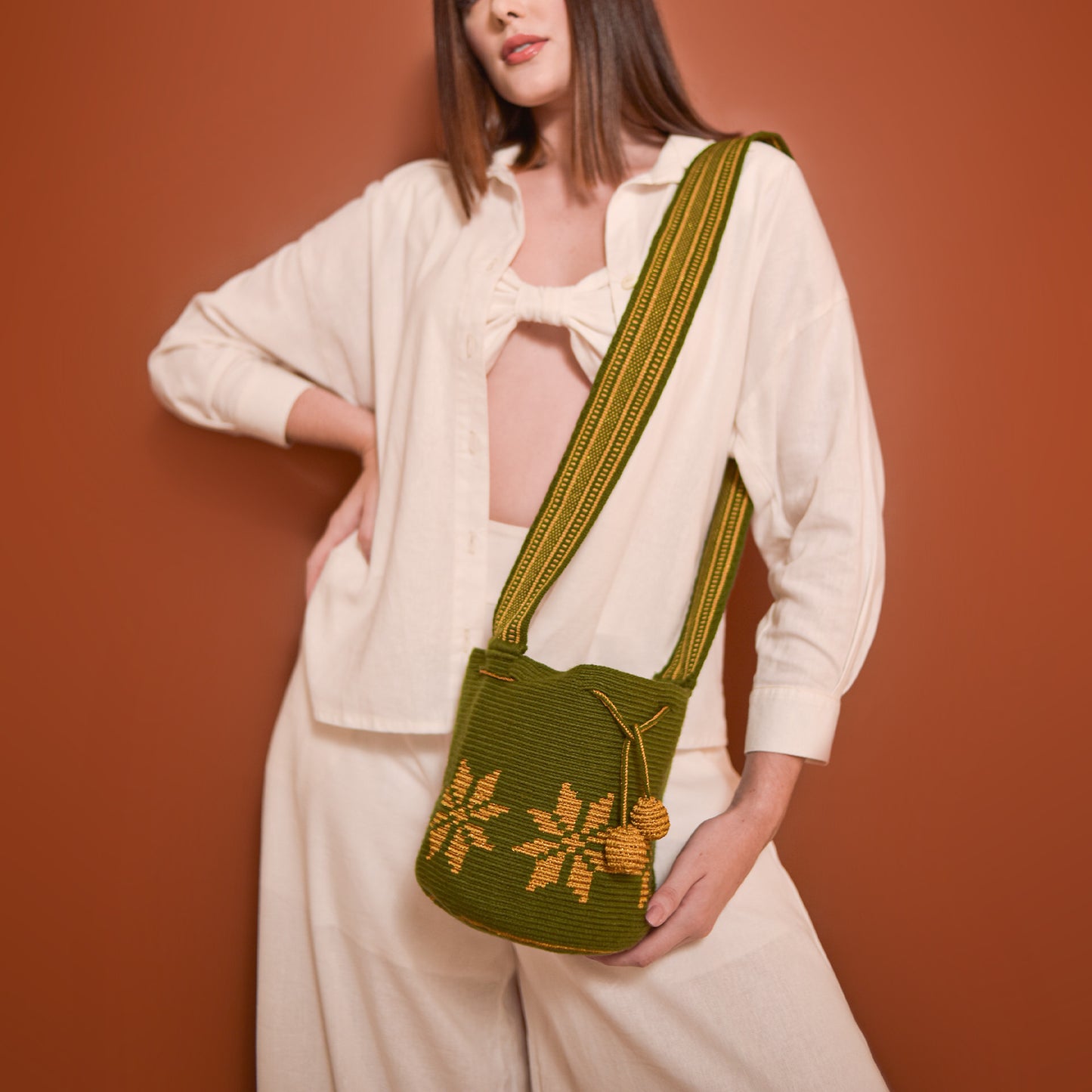 Mochila Marlen, mochila artesanal hecha a mano por artesanas de la comunidad Wayuu en el norte de Colombia. Tejida con hilos de algodón y seda dorada. Su diseño de flores tejidas aporta elegancia atemporal, mientras que su gasa larga y cordón ajustable. Mochila wayuu, mochila colombiana, bolso colombiano, bolso artesanal, mochila artesanal, color verde militar.