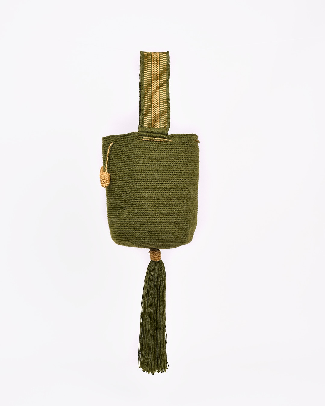 Mochila Tara Wayuu artesanal color verde militar, tejida a mano con hilos de algodón y seda dorada en el norte de Colombia. Mini mochila de diseño monocromático, con textura destacada, gasa corta, cordón ajustable y bailarina colgante. Fusión de tradición y elegancia contemporánea. Mochila Wayuu, mochila de fiesta, bolso wayuu, bolso de fiesta.