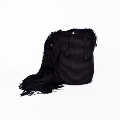 Mochila Flecos, pieza artesanal hecha a mano por artesanas de la comunidad Wayuu en el norte de Colombia. Confeccionada con hilos de algodón y flecos de seda dorada, combina la tradición Wayuu con un diseño vibrante y sofisticado. Su asa larga permite llevarla cruzada, ofreciendo un accesorio único, versátil y lleno de personalidad. Mochila Wayuu, Mochila artesanal, mochila colombiana.
