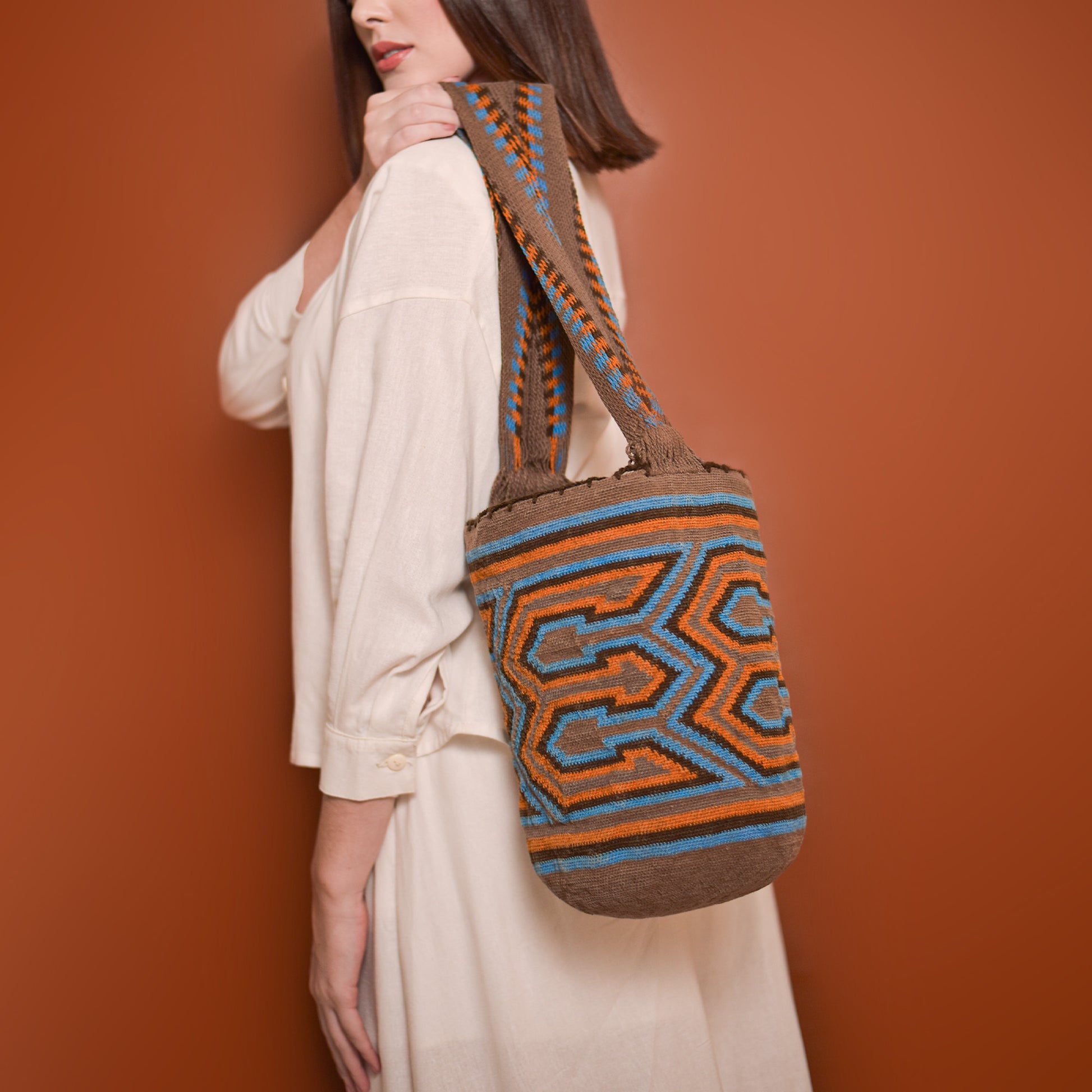 Mochila Poporo, bolso artesanal colombiano tejido a mano por artesanas Arhuacas de la Sierra Nevada. Elaborada con lana de oveja e hilos de algodón teñidos con tintes naturales. Incluye gasa de largo especial y diseño funcional que respeta la tradición Arhuaca. Pieza única que representa el conocimiento ancestral y la conexión con la naturaleza.