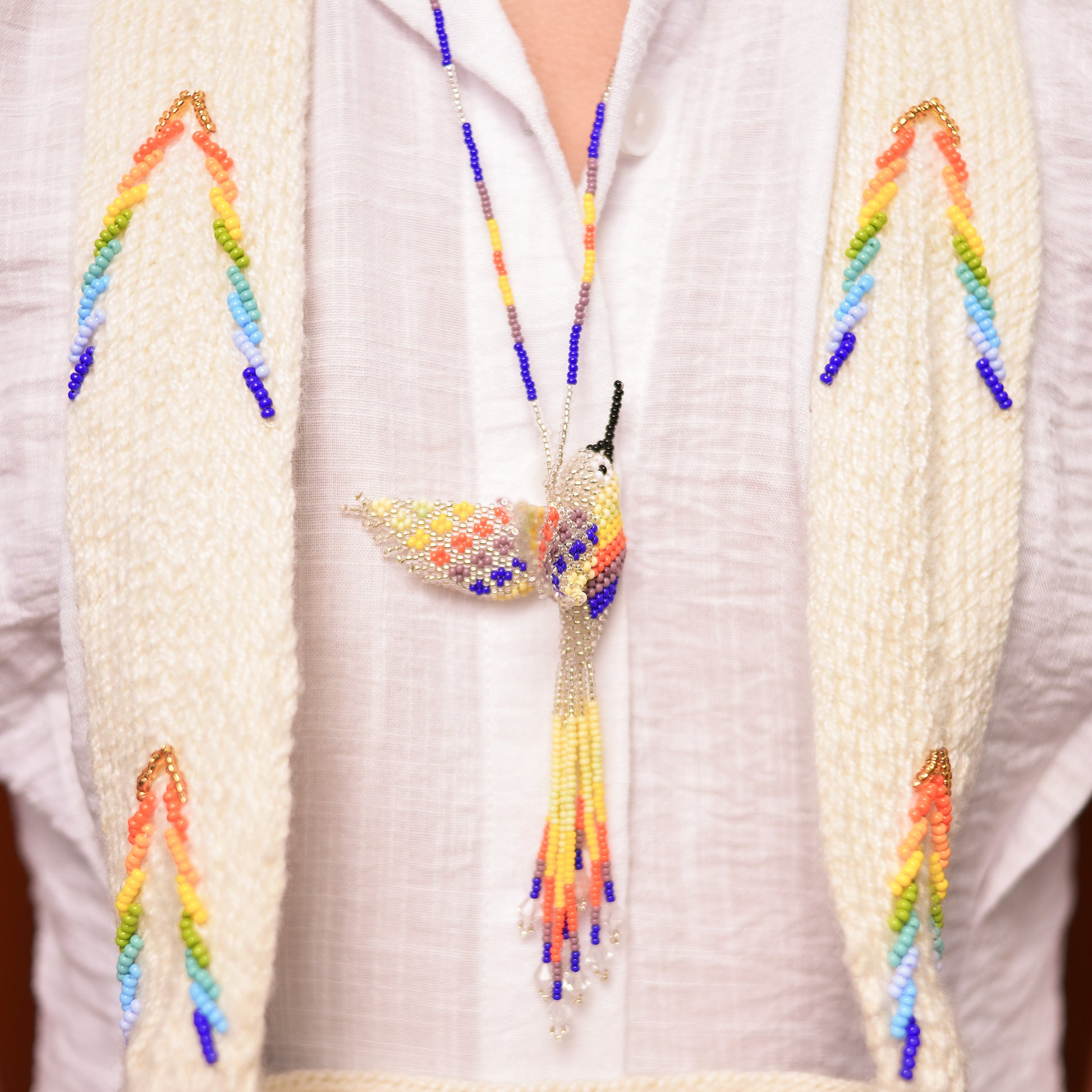 Collar Colibrí artesanal, tejido a mano con mostacillas por la comunidad Emberá en Colombia. Diseño colorido inspirado en el colibrí, símbolo de alegría y libertad.