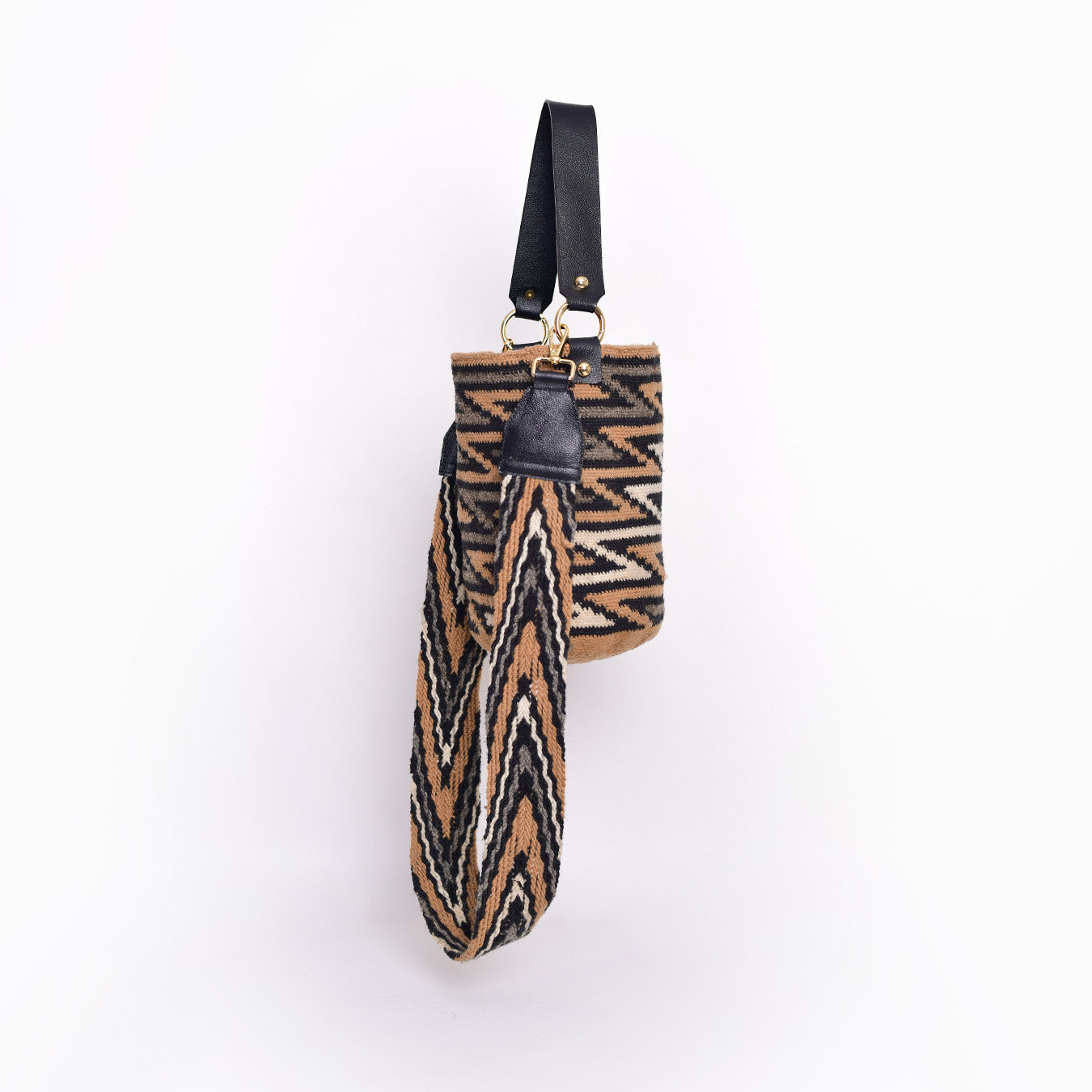Mochila Ruth, pieza artesanal hecha a mano por artesanas de la comunidad Kankuama en la Sierra Nevada de Colombia. Su diseño innovador combina tradición y modernidad, con doble asa: una tejida a mano y extraíble mediante ganchos, y otra en cuero para un toque sofisticado. Esta mochila refleja la identidad cultural y habilidad excepcional de las artesanas Kankuamas.