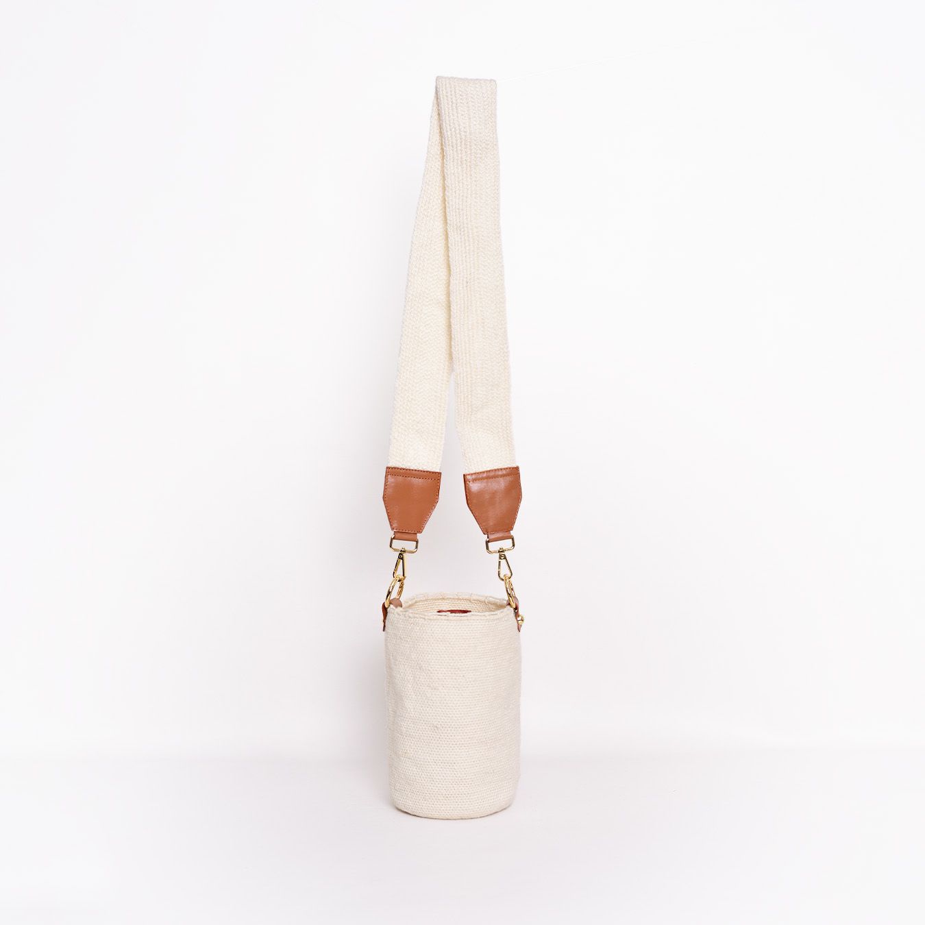 Mochila Carmen, mini mochila artesanal hecha a mano por artesanos Kankuamos en Colombia. Combina tejido artesanal con detalles en cuero y herrajes de alta calidad, fusionando tradición y modernidad en un diseño elegante y funcional. Ideal para quienes buscan un accesorio auténtico, práctico y sofisticado.