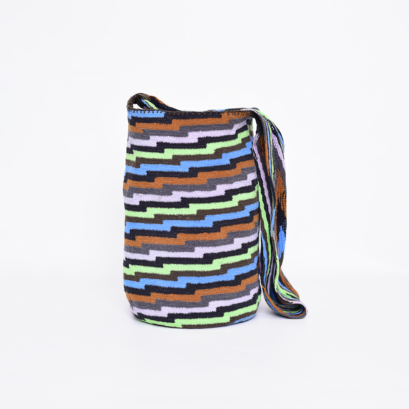 Mochila Poporo, bolso artesanal colombiano tejido a mano por artesanas Arhuacas de la Sierra Nevada. Elaborada con lana de oveja e hilos de algodón teñidos con tintes naturales. Incluye gasa de largo especial y diseño funcional que respeta la tradición Arhuaca. Pieza única que representa el conocimiento ancestral y la conexión con la naturaleza.