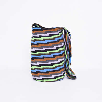 Mochila Poporo, bolso artesanal colombiano tejido a mano por artesanas Arhuacas de la Sierra Nevada. Elaborada con lana de oveja e hilos de algodón teñidos con tintes naturales. Incluye gasa de largo especial y diseño funcional que respeta la tradición Arhuaca. Pieza única que representa el conocimiento ancestral y la conexión con la naturaleza.
