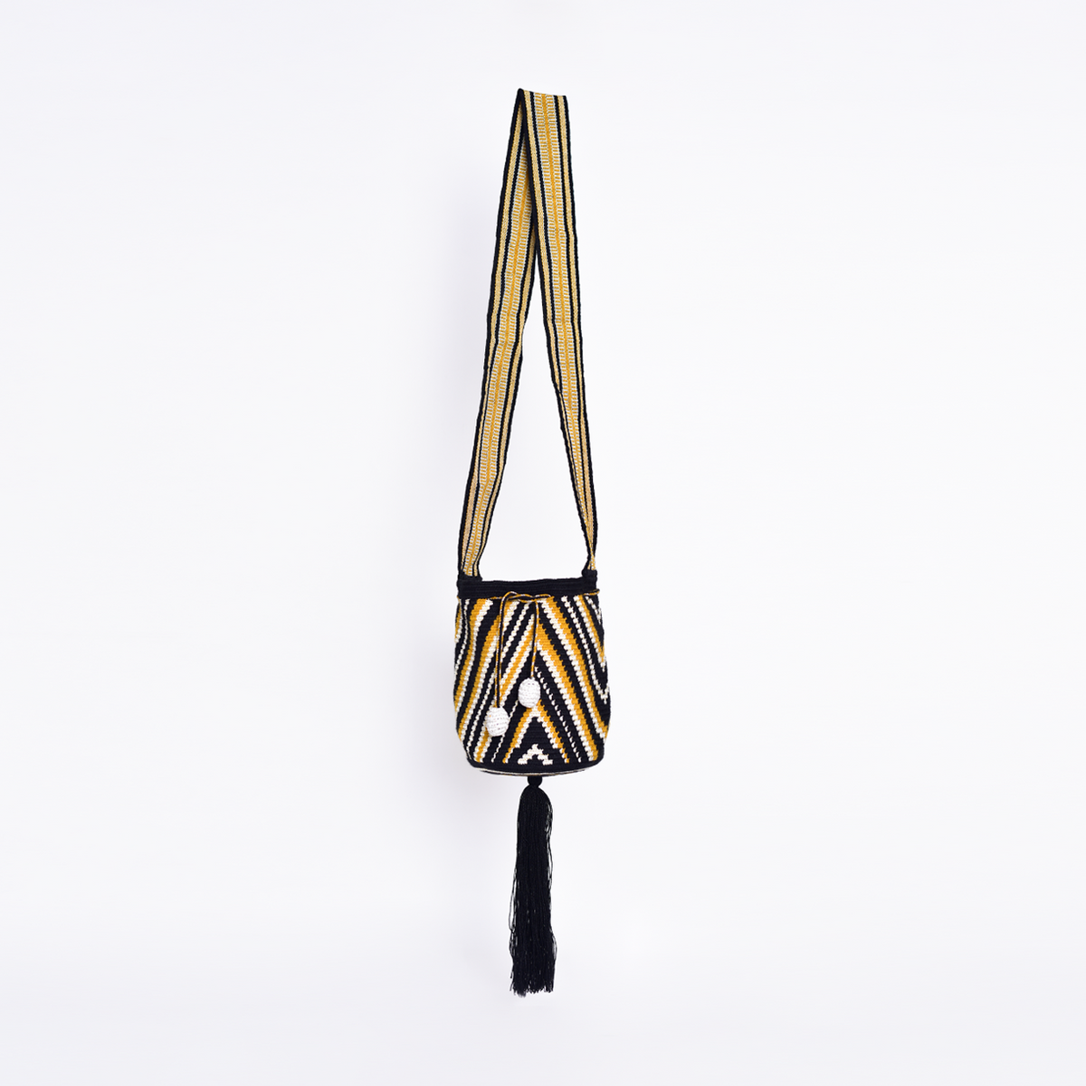 Mochila Nadina, bolso artesanal colombiano tejido a mano por artesanas Wayuu con hilos de algodón. Incluye asa larga, gasa ajustable, detalles únicos y bailarina colgante. Pieza única que combina tradición, cultura y estilo."