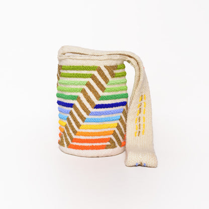 Mochila Paz, bolso artesanal recamado y hecho a mano con lana por artesanas de la comunidad Kankuama en la Sierra Nevada de Colombia. Su diseño exclusivo, adornado con mostacillas y gasa larga, refleja la identidad cultural y el arte de esta comunidad indígena. Cada pieza es única, fusionando tradición y elegancia en un accesorio versátil y auténtico.