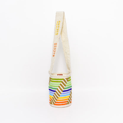 Mochila Paz, bolso artesanal recamado y hecho a mano con lana por artesanas de la comunidad Kankuama en la Sierra Nevada de Colombia. Su diseño exclusivo, adornado con mostacillas y gasa larga, refleja la identidad cultural y el arte de esta comunidad indígena. Cada pieza es única, fusionando tradición y elegancia en un accesorio versátil y auténtico.