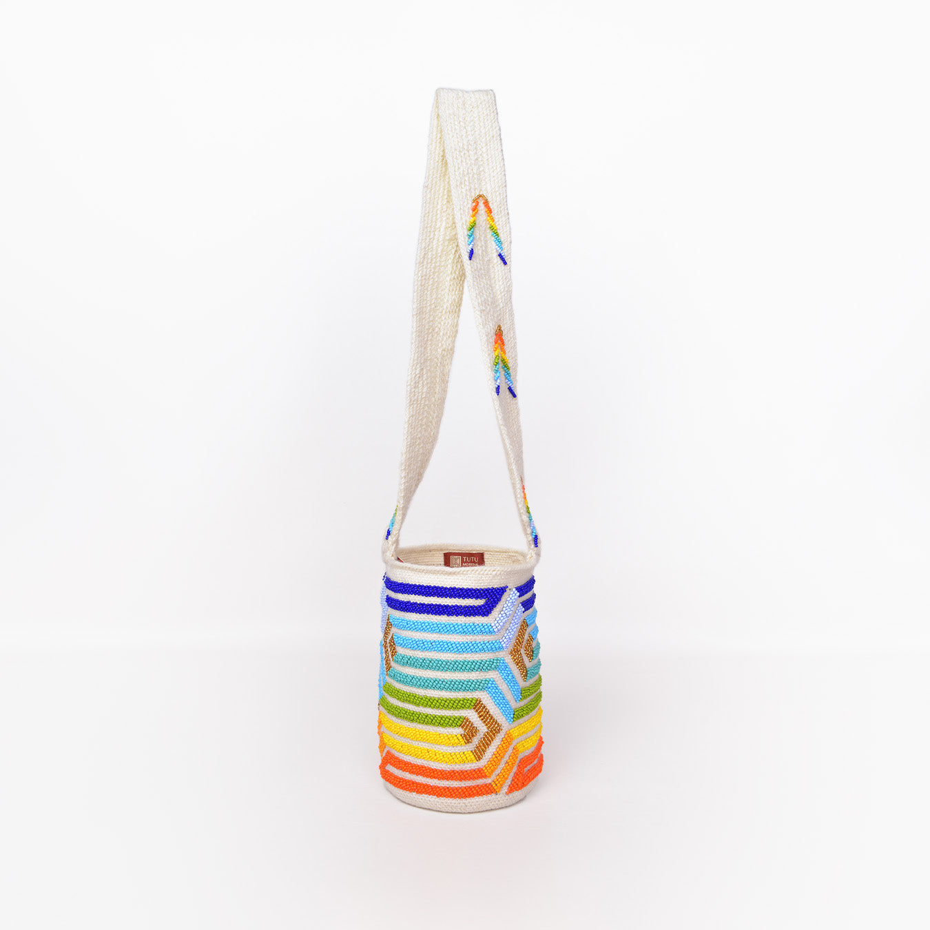 Mochila Paz, bolso artesanal recamado y hecho a mano con lana por artesanas de la comunidad Kankuama en la Sierra Nevada de Colombia. Su diseño exclusivo, adornado con mostacillas y gasa larga, refleja la identidad cultural y el arte de esta comunidad indígena. Cada pieza es única, fusionando tradición y elegancia en un accesorio versátil y auténtico.