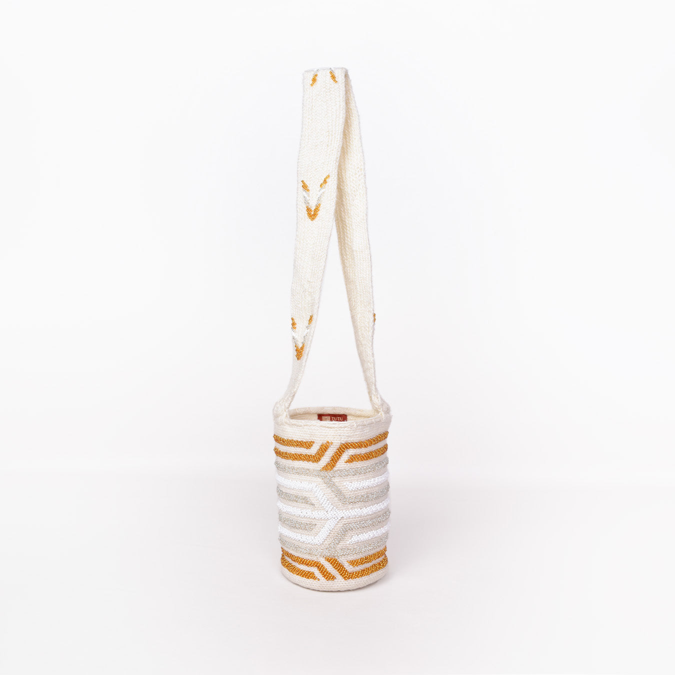 Mochila Paz, bolso artesanal recamado y hecho a mano con lana por artesanas de la comunidad Kankuama en la Sierra Nevada de Colombia. Su diseño exclusivo, adornado con mostacillas y gasa larga, refleja la identidad cultural y el arte de esta comunidad indígena. Cada pieza es única, fusionando tradición y elegancia en un accesorio versátil y auténtico.