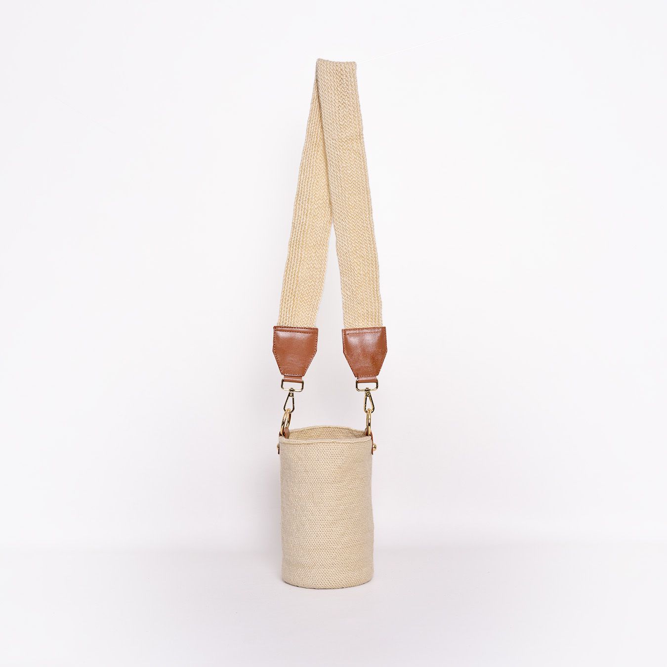 Mochila Carmen, mini mochila artesanal hecha a mano por artesanos Kankuamos en Colombia. Combina tejido artesanal con detalles en cuero y herrajes de alta calidad, fusionando tradición y modernidad en un diseño elegante y funcional. Ideal para quienes buscan un accesorio auténtico, práctico y sofisticado.