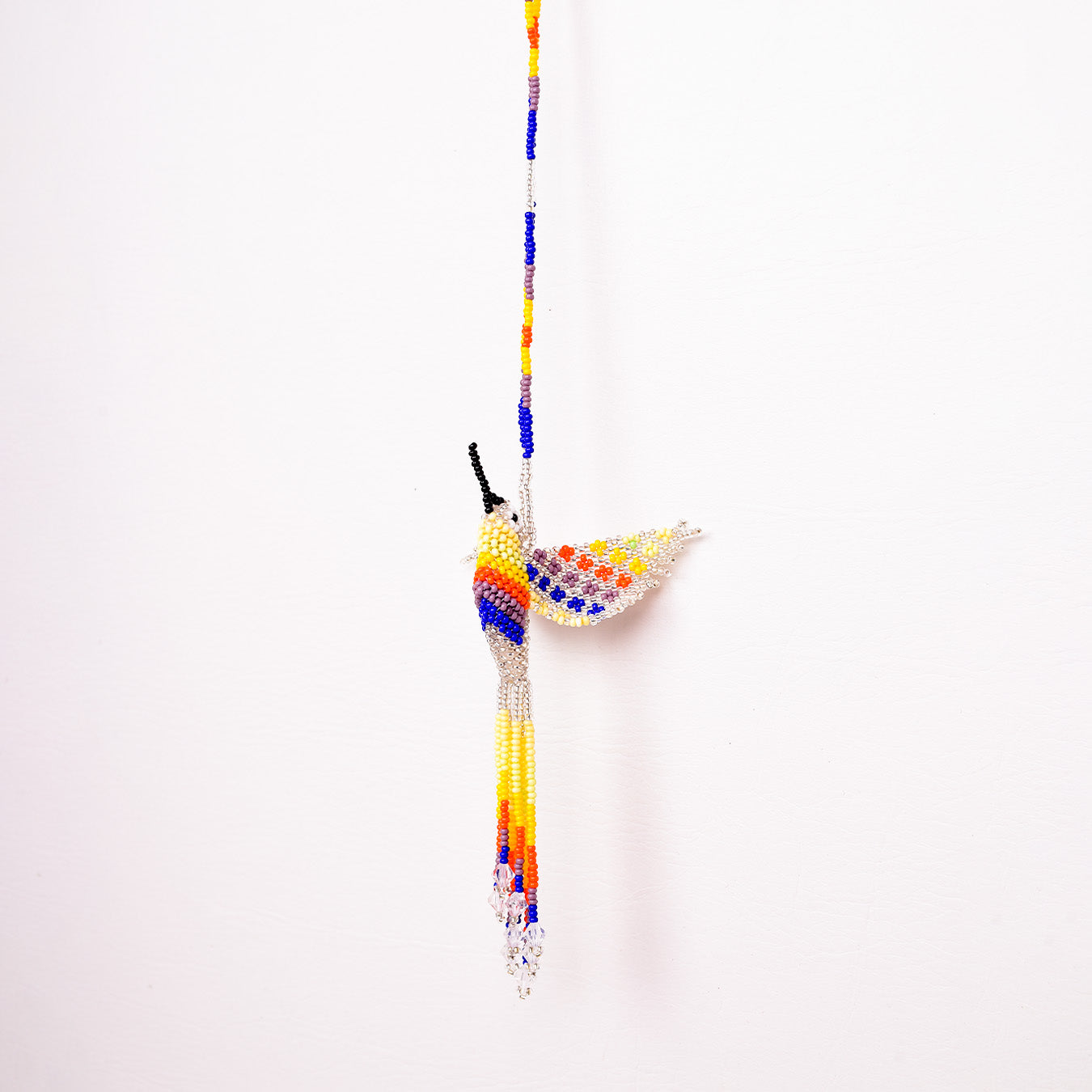 Collar Colibrí artesanal, tejido a mano con mostacillas por la comunidad Emberá en Colombia. Diseño colorido inspirado en el colibrí, símbolo de alegría y libertad.
