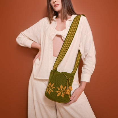 Mochila Marlen, mochila artesanal hecha a mano por artesanas de la comunidad Wayuu en el norte de Colombia. Tejida con hilos de algodón y seda dorada. Su diseño de flores tejidas aporta elegancia atemporal, mientras que su gasa larga y cordón ajustable. Mochila wayuu, mochila colombiana, bolso colombiano, bolso artesanal, mochila artesanal, color verde militar.