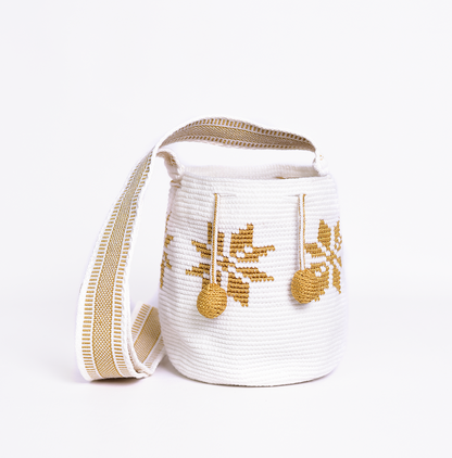 Mochila Marlen, mochila artesanal hecha a mano por artesanas de la comunidad Wayuu en el norte de Colombia. Tejida con hilos de algodón y seda dorada. Su diseño de flores tejidas aporta elegancia atemporal, mientras que su gasa larga y cordón ajustable. Mochila wayuu, mochila colombiana, bolso colombiano, bolso artesanal, mochila artesanal, color blanco.