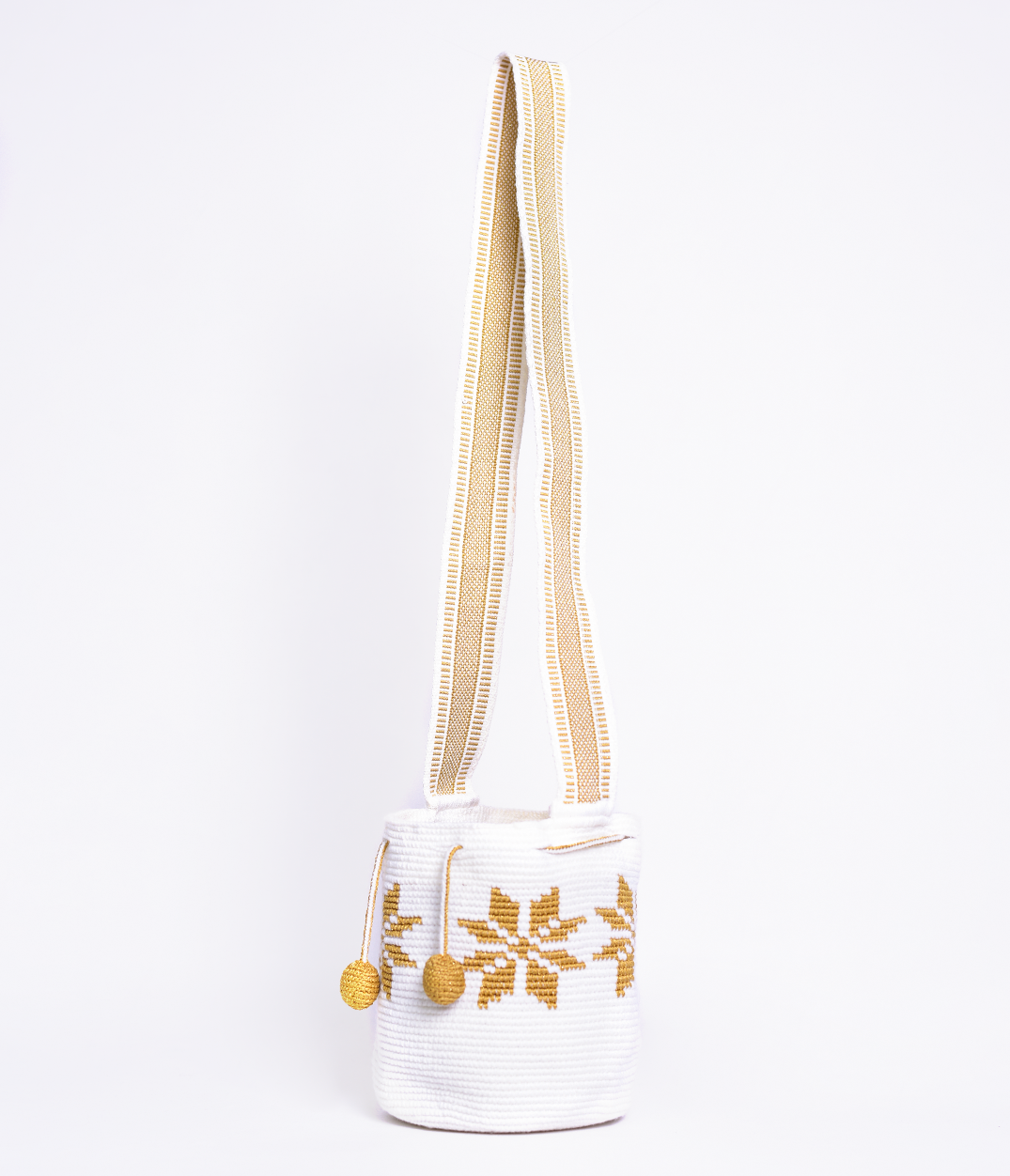Mochila Marlen, mochila artesanal hecha a mano por artesanas de la comunidad Wayuu en el norte de Colombia. Tejida con hilos de algodón y seda dorada. Su diseño de flores tejidas aporta elegancia atemporal, mientras que su gasa larga y cordón ajustable. Mochila wayuu, mochila colombiana, bolso colombiano, bolso artesanal, mochila artesanal, color blanco.