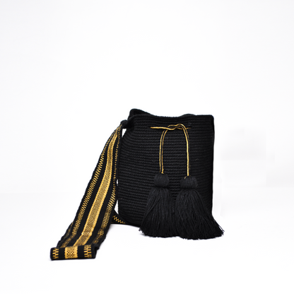 Mochila Sami, mini mochila Wayuu hecha a mano por artesanas de la comunidad Wayuu en La Guajira, Colombia. Tejida con hilos brillantes, su diseño delicado y sofisticado se complementa con una asa larga que aporta un toque elegante y versátil. 