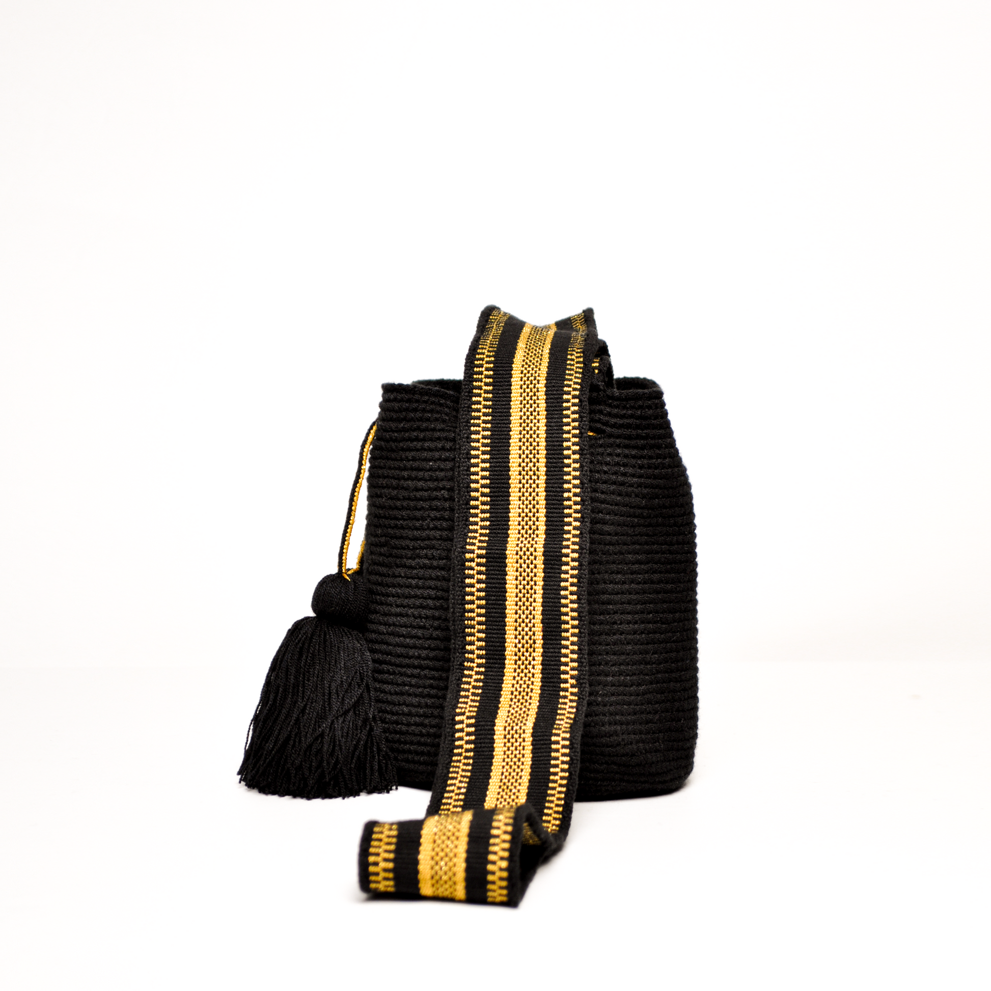 Mochila Sami, mini mochila Wayuu hecha a mano por artesanas de la comunidad Wayuu en La Guajira, Colombia. Tejida con hilos brillantes, su diseño delicado y sofisticado se complementa con una asa larga que aporta un toque elegante y versátil. 