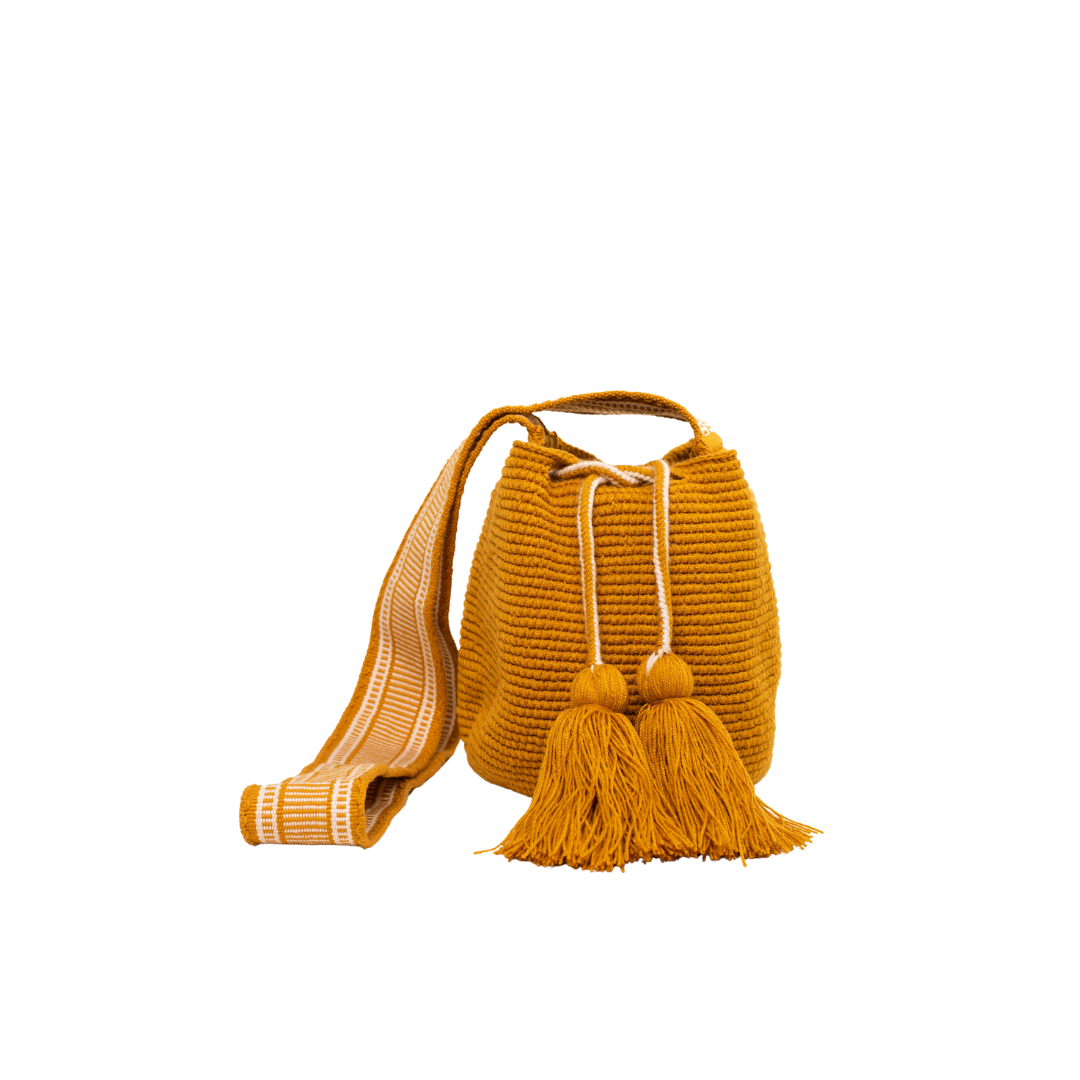 Mochila Amaranta Wayuu, elaborada a mano por artesanas de la comunidad Wayuu en el norte de La Guajira, Colombia. Esta mochila única destaca por su diseño auténtico y práctico, tejida 100% a mano con dedicación. Cuenta con un asa larga para llevarla cómodamente al hombro o cruzada, y dos bailarinas ajustables que no solo aportan un toque decorativo, sino que también garantizan un cierre seguro para proteger tus pertenencias. Color mostaza.