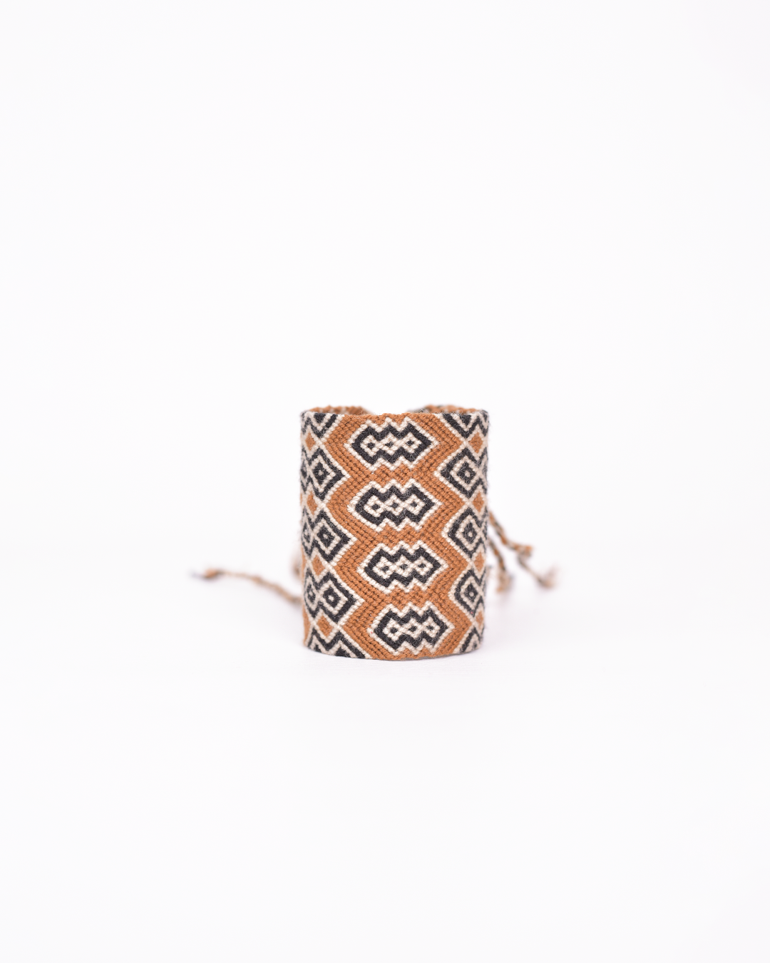 Pulsera Wayuu tejida a mano con cuatro vueltas de hilos de algodón, destacando por su diseño colorido y artesanal.